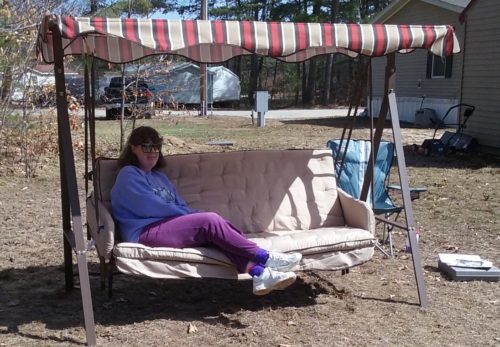 Wendy-Little-sitting-on-outdoor-rocking-couch